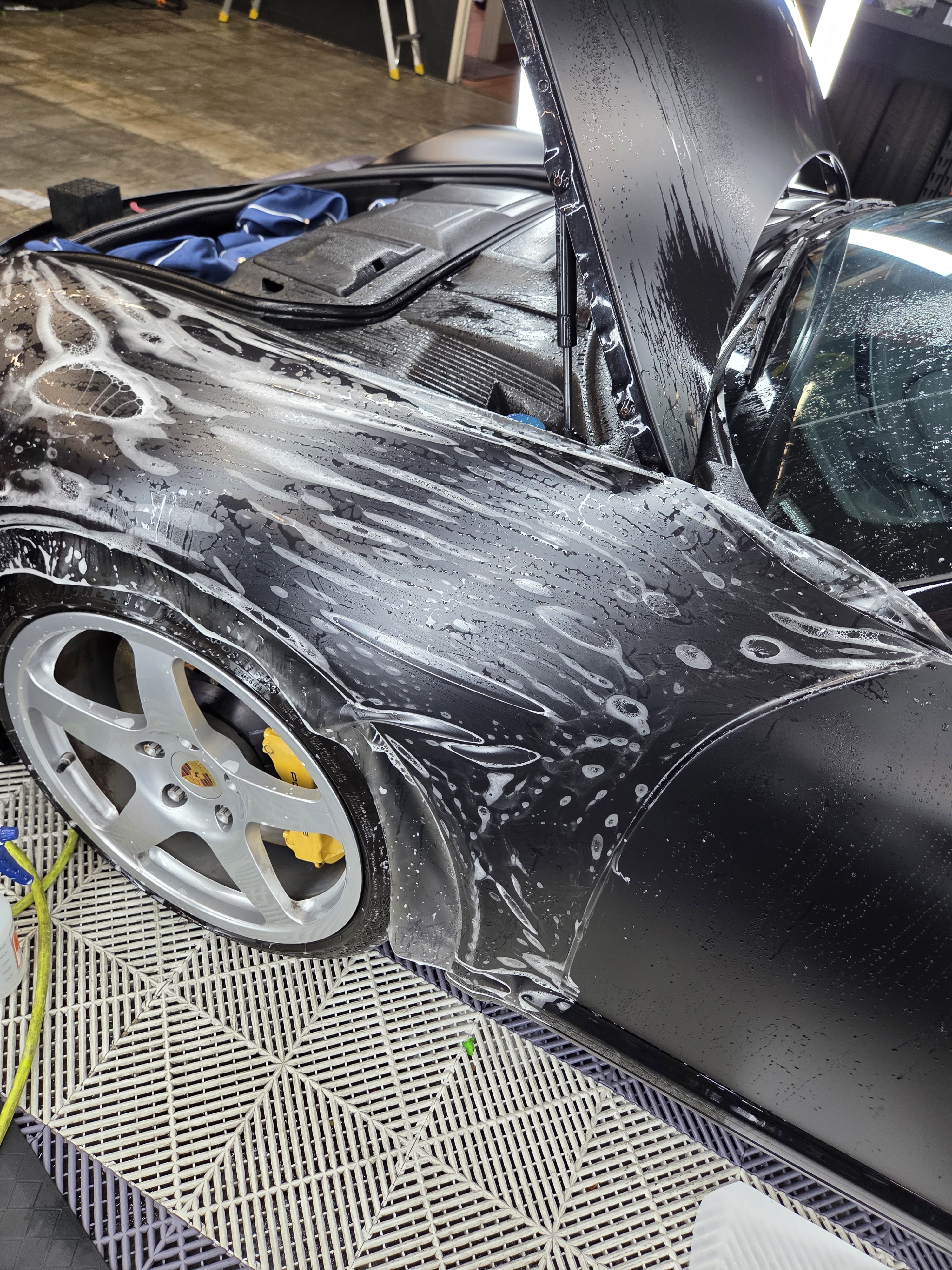 Detailers working on a vehicle by hand